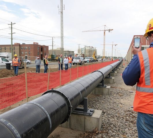 A dramatic view of a symmetric industrial tunnel lined with steel pipes.
